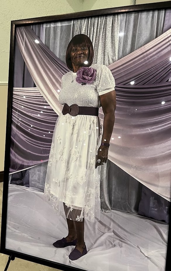Framed portrait of Vicki Smith Ross in a white lace skirt with a purple rose